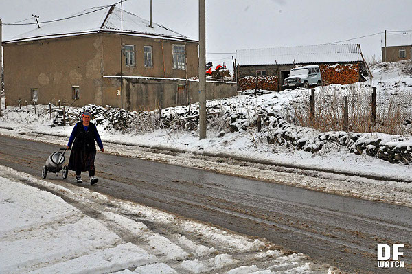 Woman pulling a milk contained along snowy road