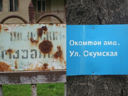 old (in Russian and Georgian) and new (in Abkhaz and Russian) street name sign in Gali (Dominik K. Cagara)
