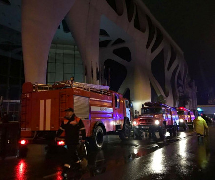 Firefighters scramble outside the burning hotel